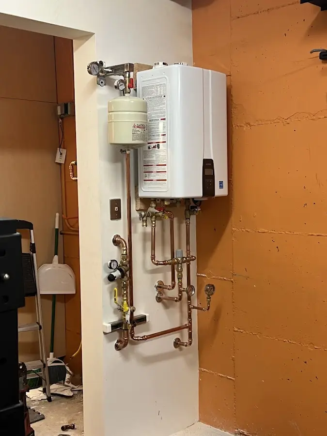 Plumbing technician inspecting water heater connections in Southbury